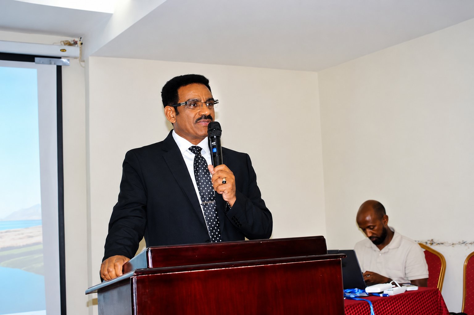 A speaker addressing guests at the Grand Opening