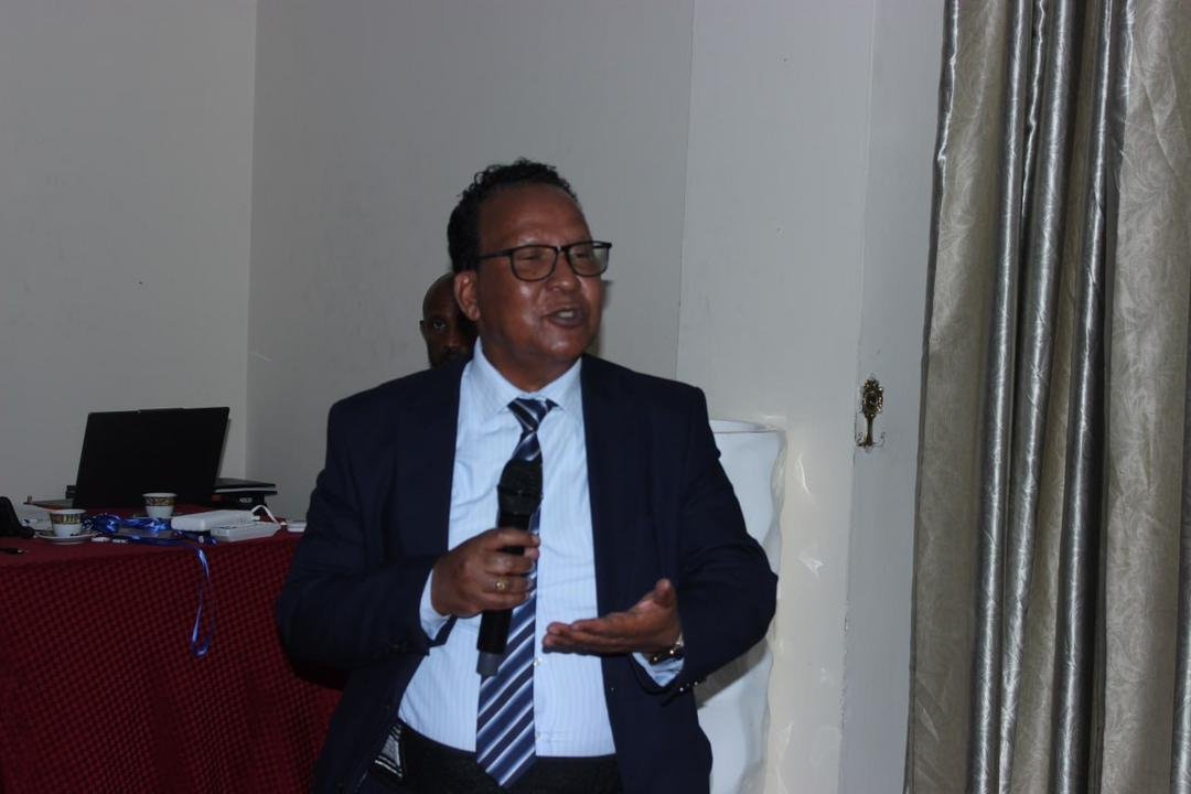 A speaker addressing guests at the Grand Opening