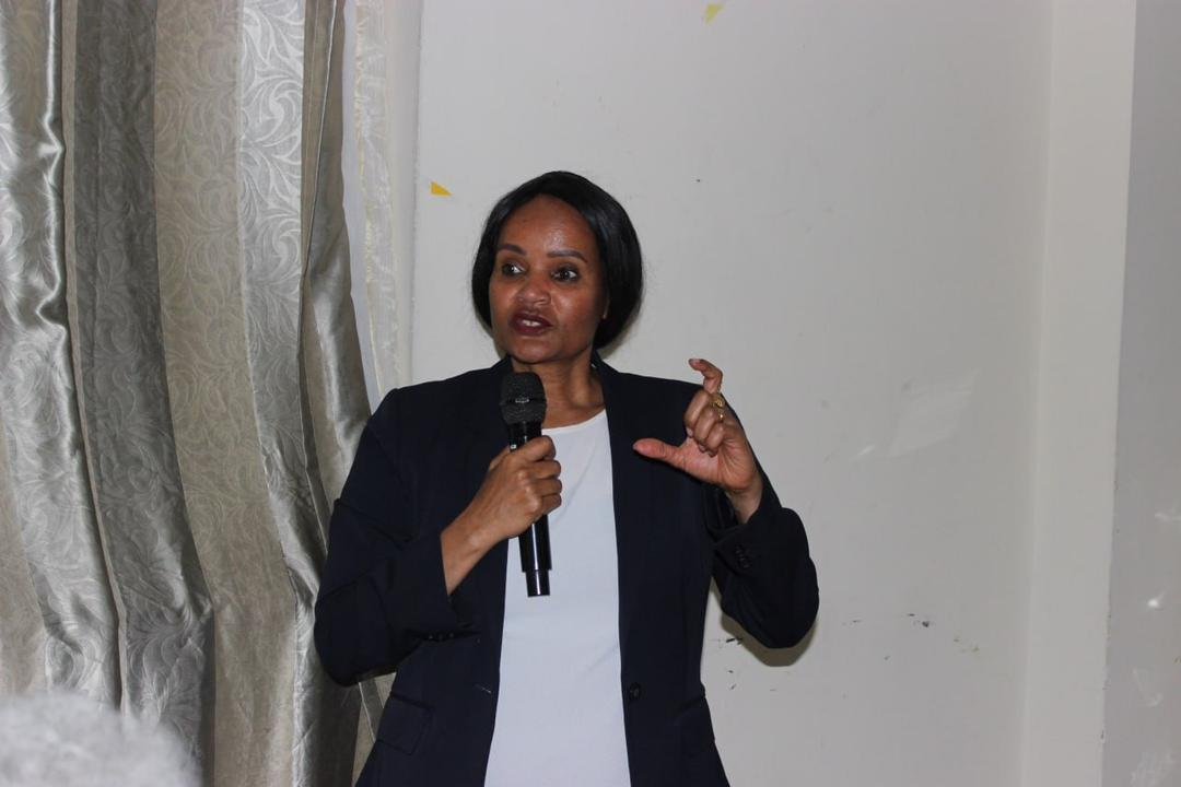 A speaker addressing guests at the Grand Opening